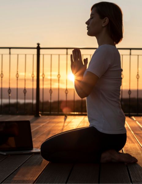 Frau macht Yoga auf dem Balkon